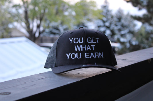 YOU GET WHAT YOU EARN - Black trucker Hat
